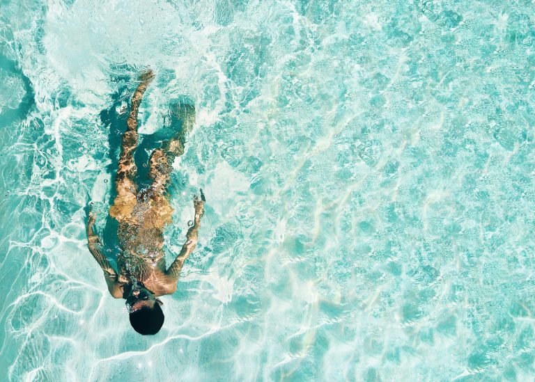 Homem tomando banho de piscina.