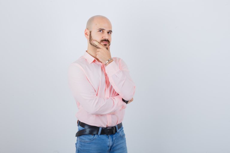 Homem de camisa rosa expressando dúvidas.